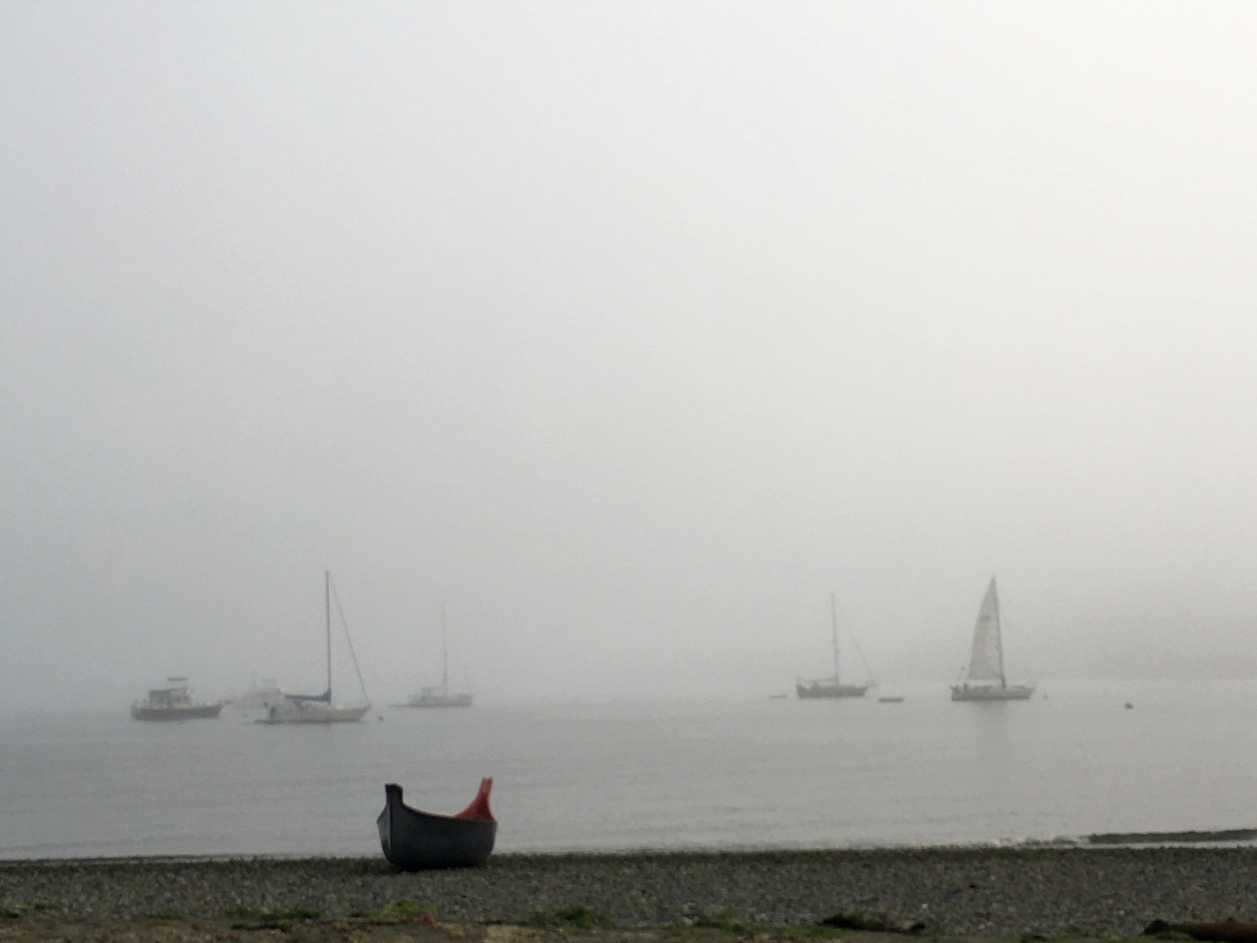 Fog surrounding the spit, plenty of anchorage and a rocky beach.