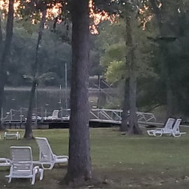lawn chairs in grass area, floating dock used to launch kayaks