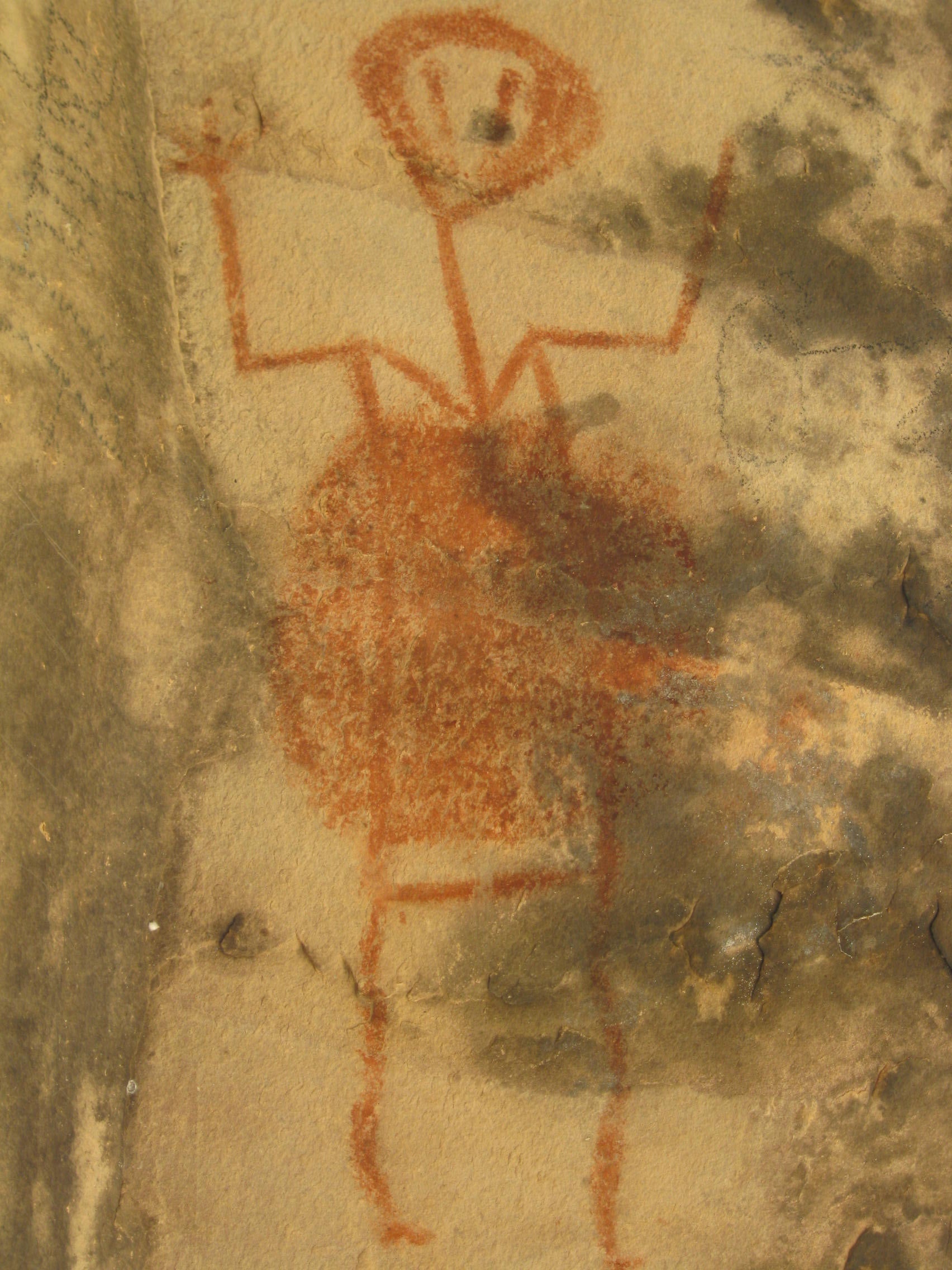 This pictograph is painted on the ceiling of the overhang. Note the v-neck and the red circle (likely a shield), which is indicative to Wyoming. The eyes have "tears," which could mean this is a water being -- a spirit from another world. I'm speculating this is a water "ghost" because there were three separate turtle pictographs here, and turtles are known servants to water beings because they can't leave the water.