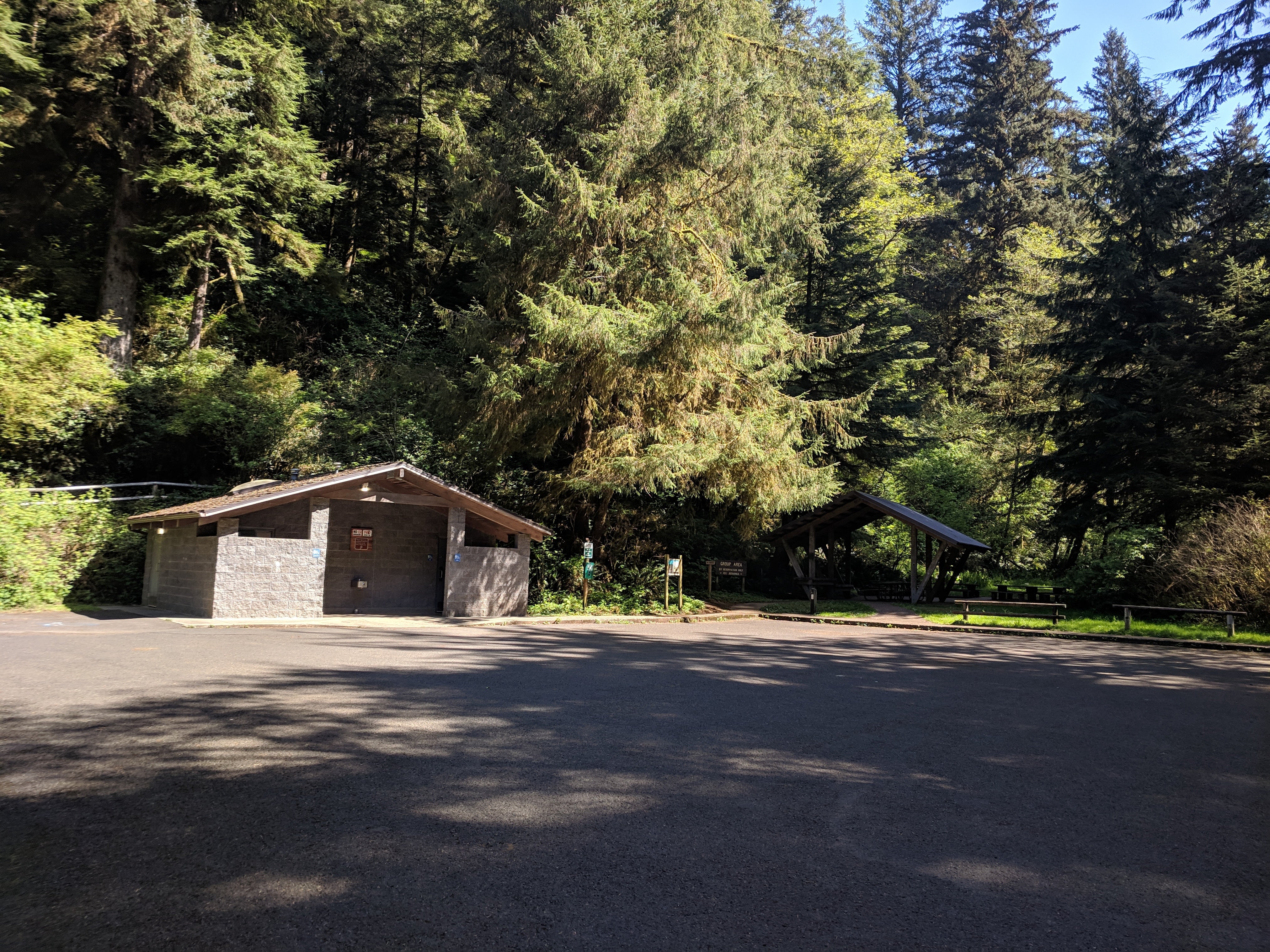One of the many bath houses at. Cape Perpetua campground. Men's and women's flush toilets and sinks. Nothing fancy, but clean, and much appreciated! In the background you can see the group camp pavilion.