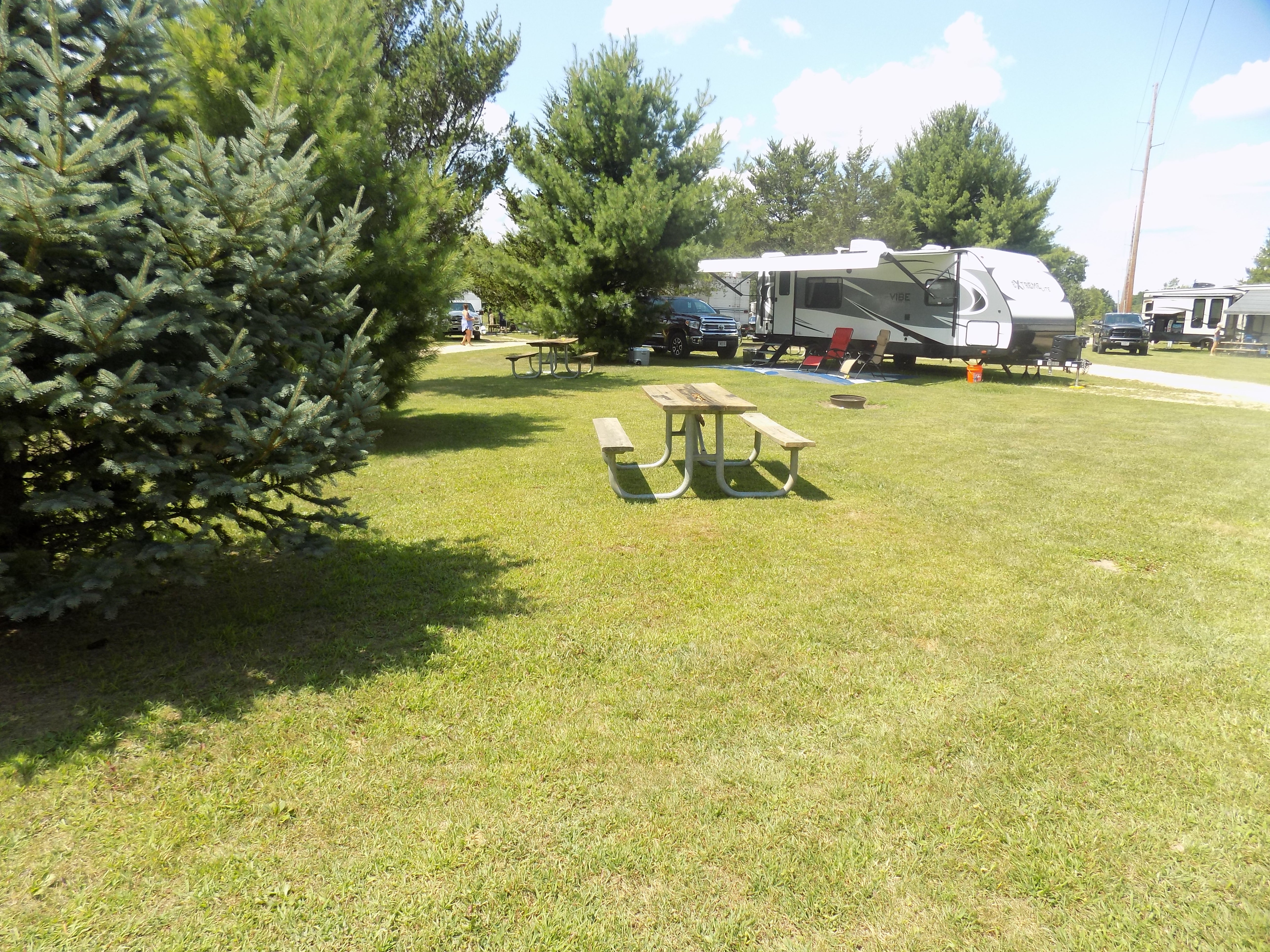 Our campsites have water, electric (20/30/50 amp), picnic table, fire-ring. We do have full hook up sites as well that offer sewer hook up. Onsite:
Garbage, dump station, restrooms, showers, volleyball court, horseshoe pit, laundry, pool, hot tub, porta potty, tiki bar, water, bar and restaurant.
