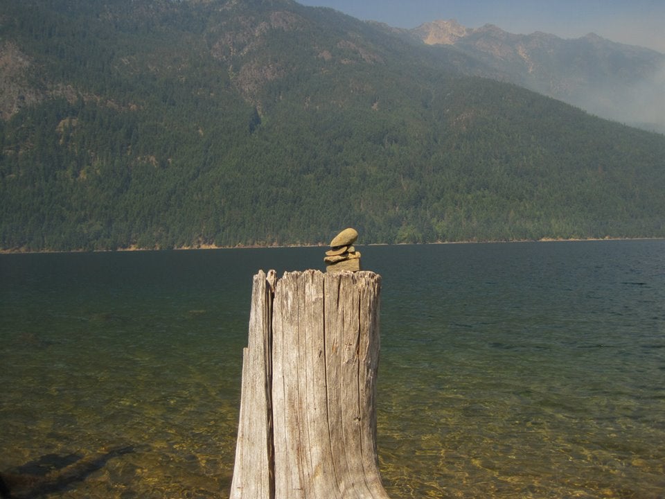 Little rock cairns adorning tree stumps in the lake