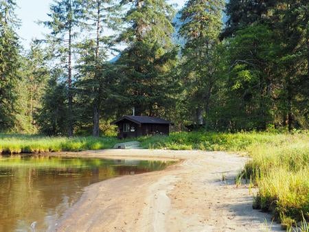 Marten Lake Cabin with trees surrounding it and water in front with a small boat



Marten Lake Cabin exterior

Credit: USFS