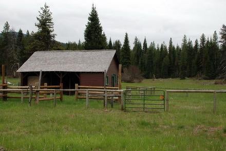 Cabin with red siding and fences in flat meadow backed by conifer forest



Lodgepole guard station

Credit: USFS