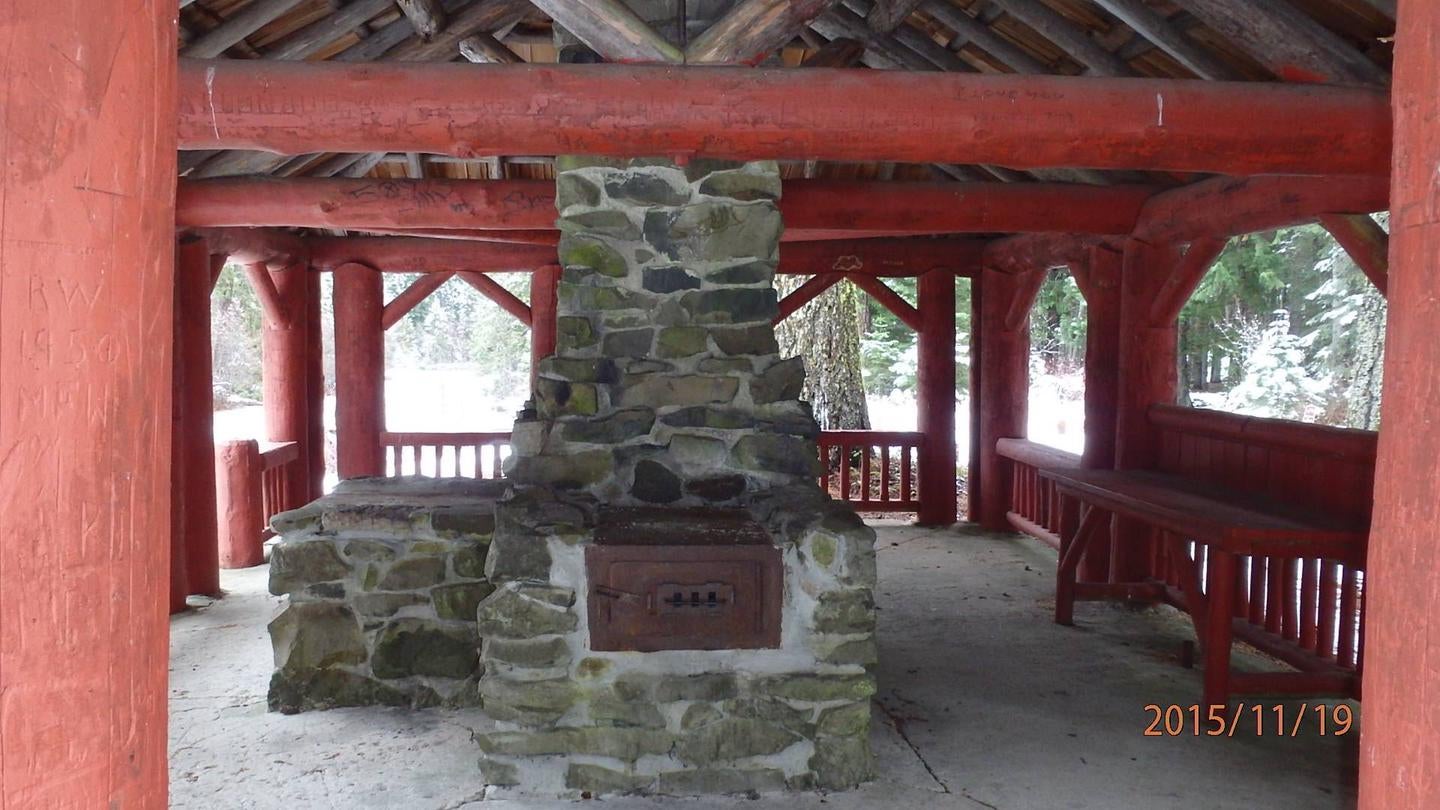 Stone fireplace and chimney next to counter under red-painted log shelter.



CCC era picnic shelter

Credit: Khill/USFS
