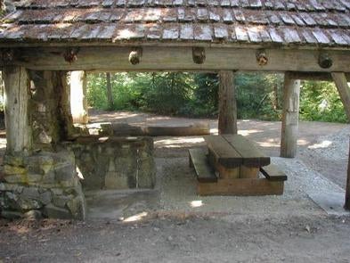 Cascadian style pole shelter protecting picnic table next to stone fireplace and chimney.



Silver falls group site

Credit: USFS