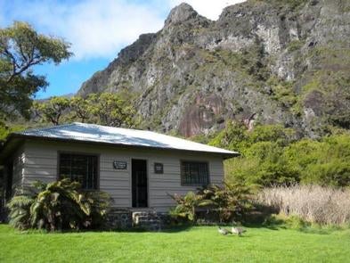 tan cabin with lush greenery surrounding with tall cliff in background



Palik__ Cabin

Credit: NPS Photo