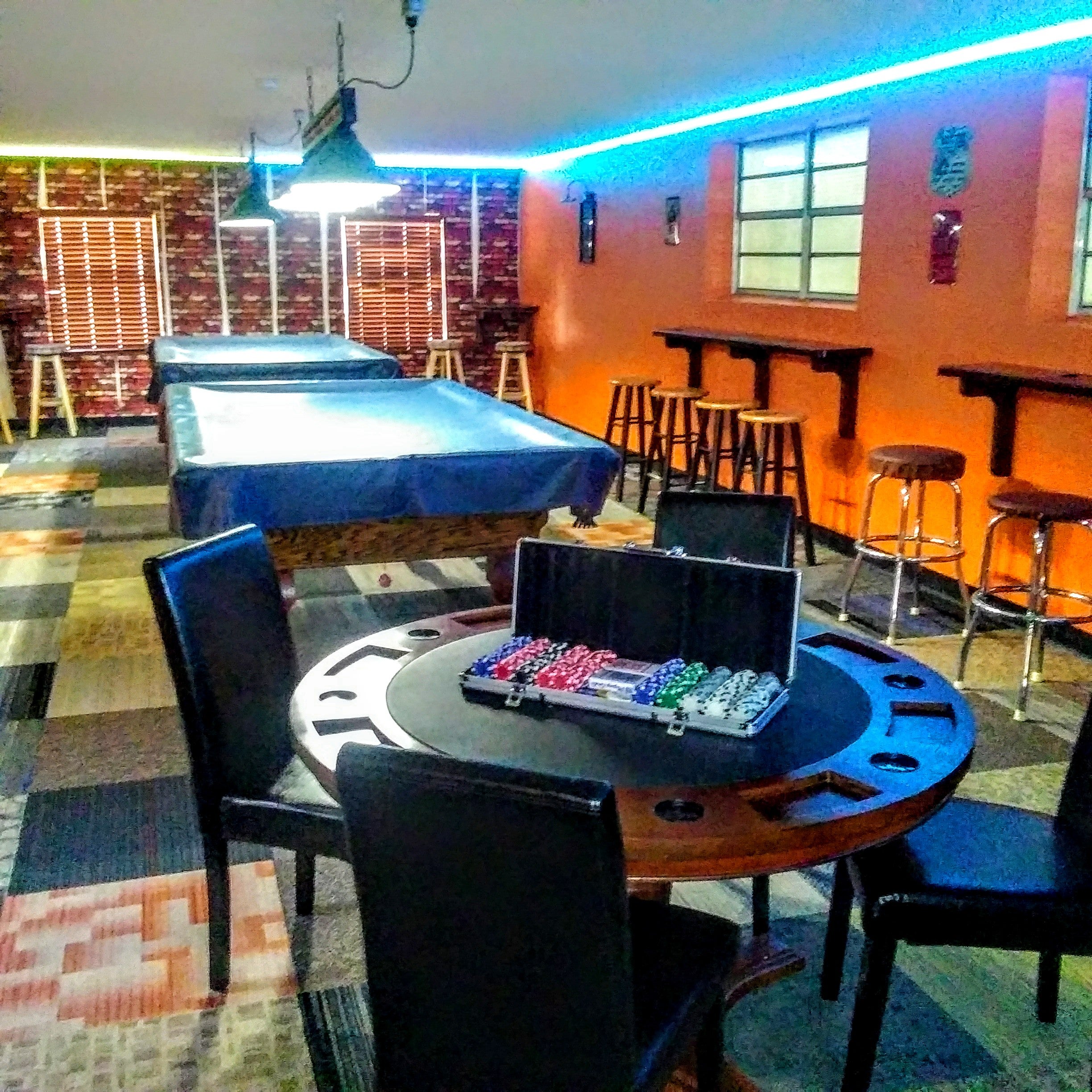 Newly remodeled game room with pool tables, darts, poker table and bar.