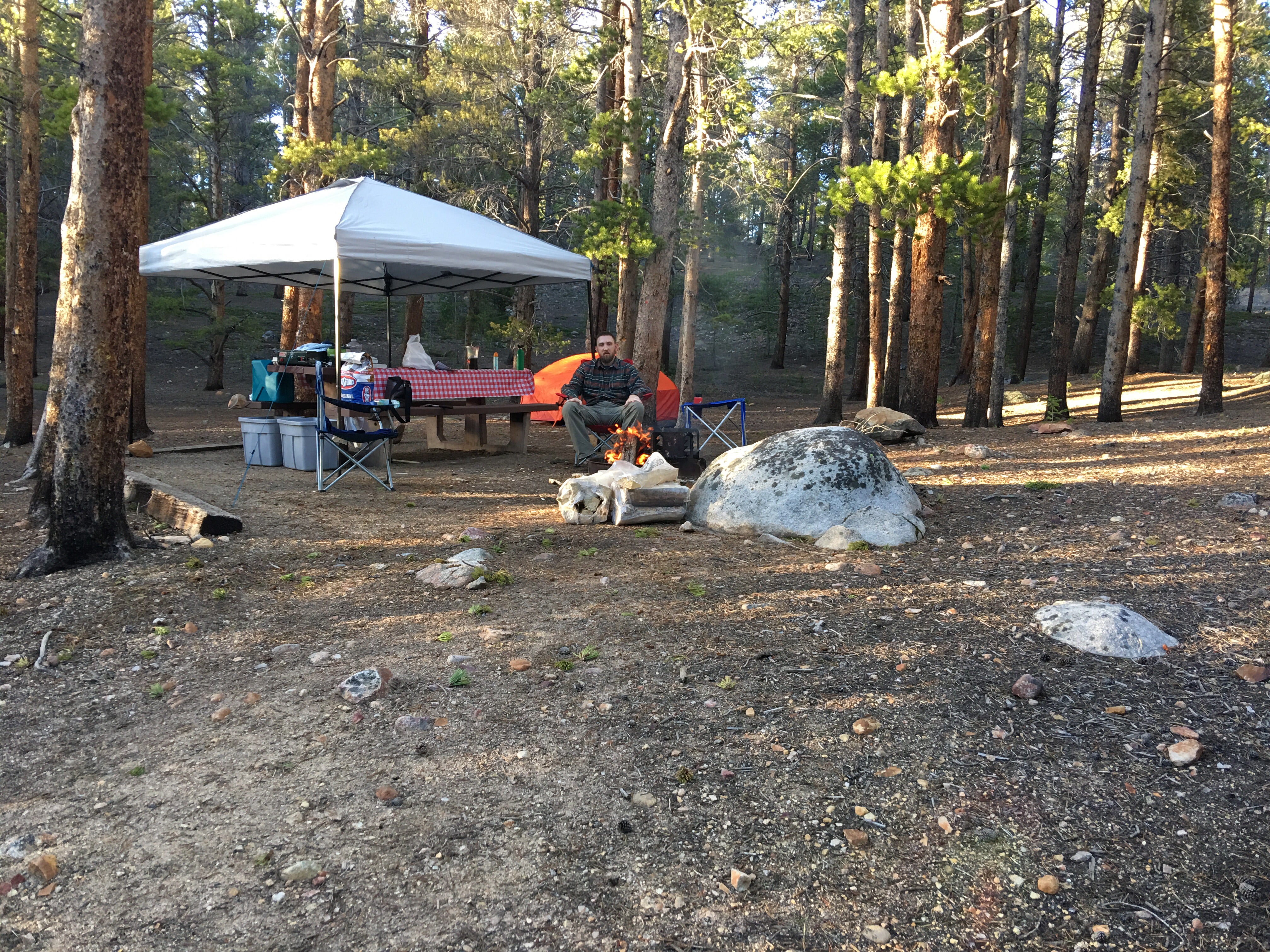 Picnic table and fire pit in great condition.  Tent at back of site with trees all around.  