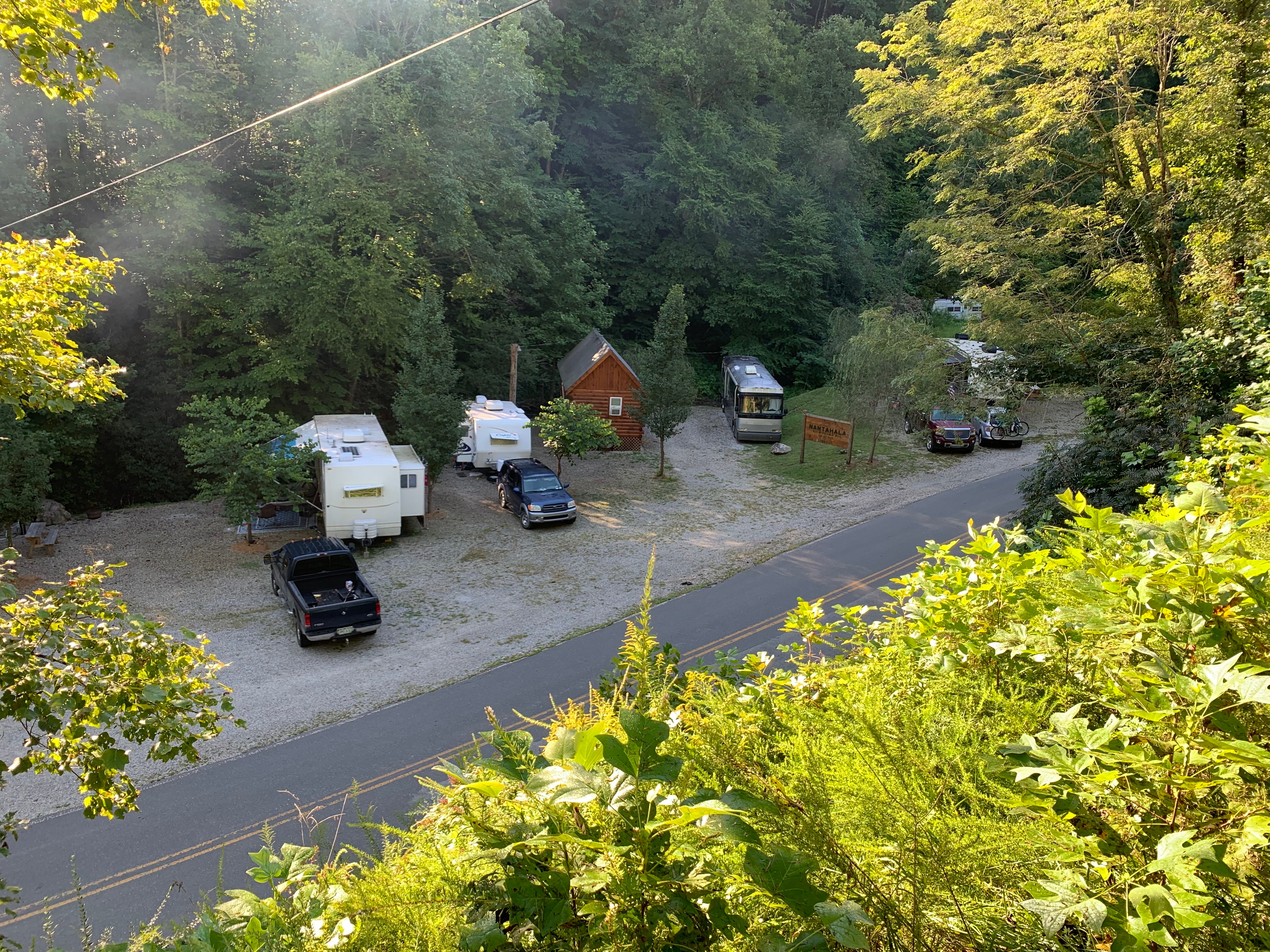 View of RV sites and a tiny home from top where tent sites are located.