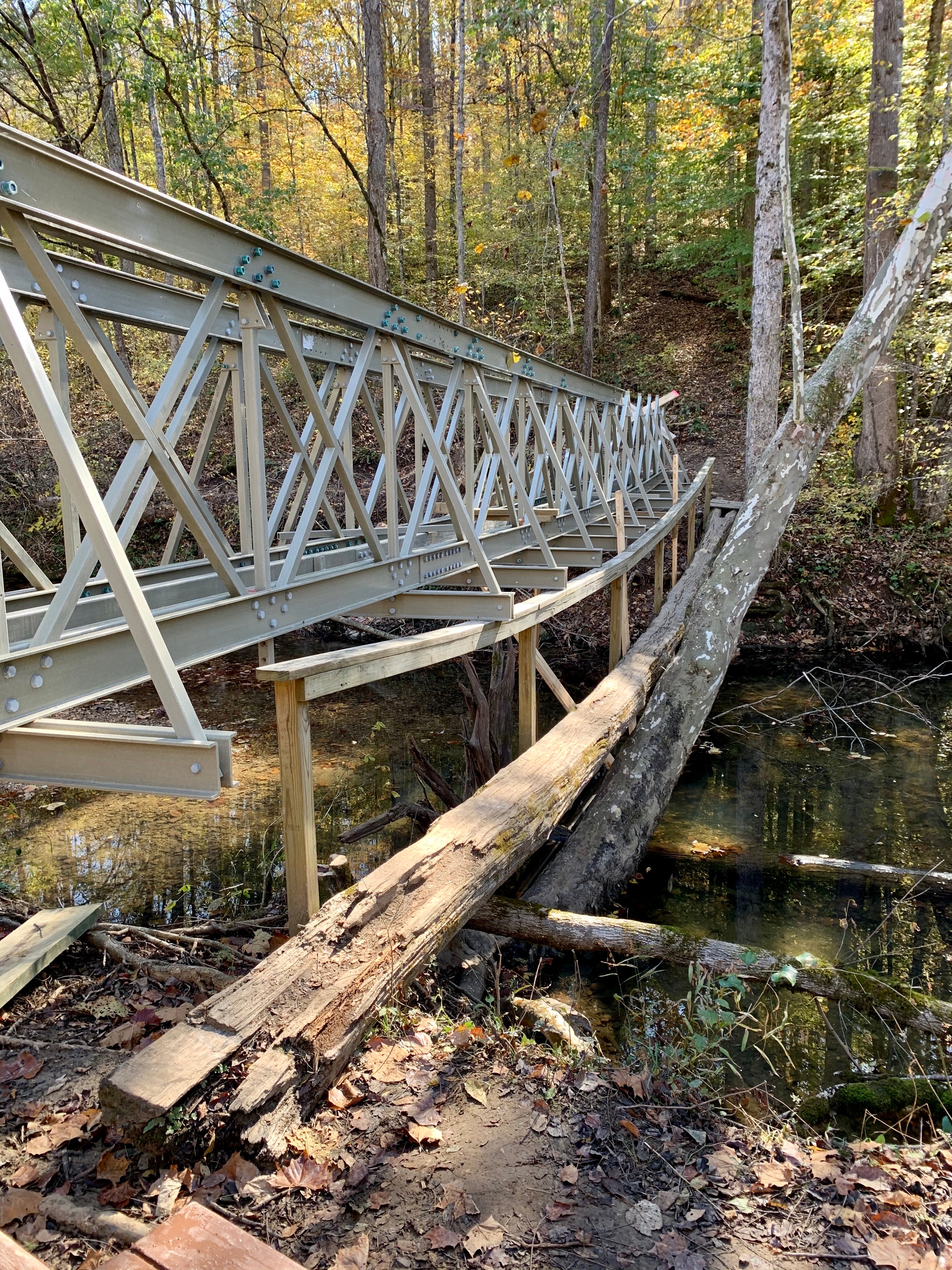 Old log bridge over Hurricane Creek is being replaced with a much larger composite constructed bridge