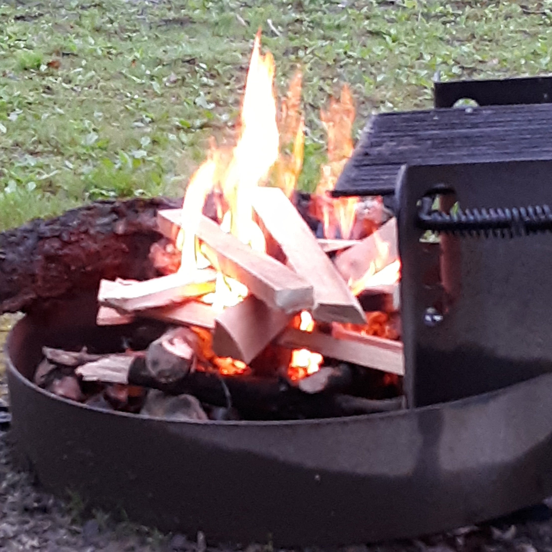 When the grill rack is lowered, it tilts into the fire