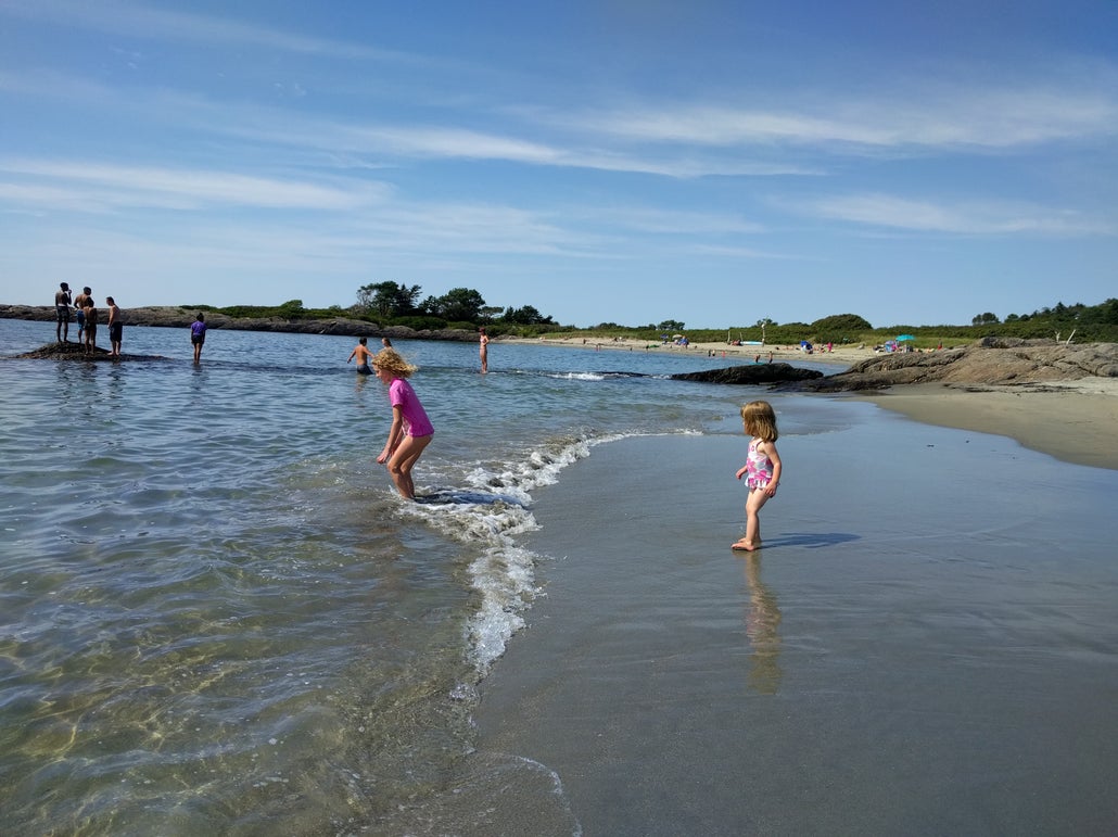 Young girls play in the shallow beach on the shore of Hermit Island, Maine