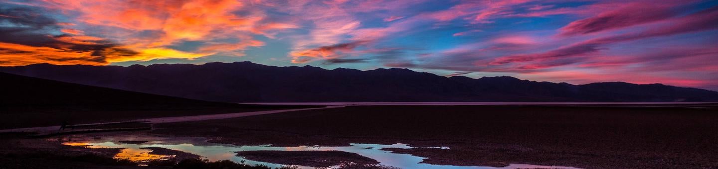 colorful sunset over wide landscape of mountains and small pool of water



Death Valley Sunset

Credit: NPS / M. Hardridge
