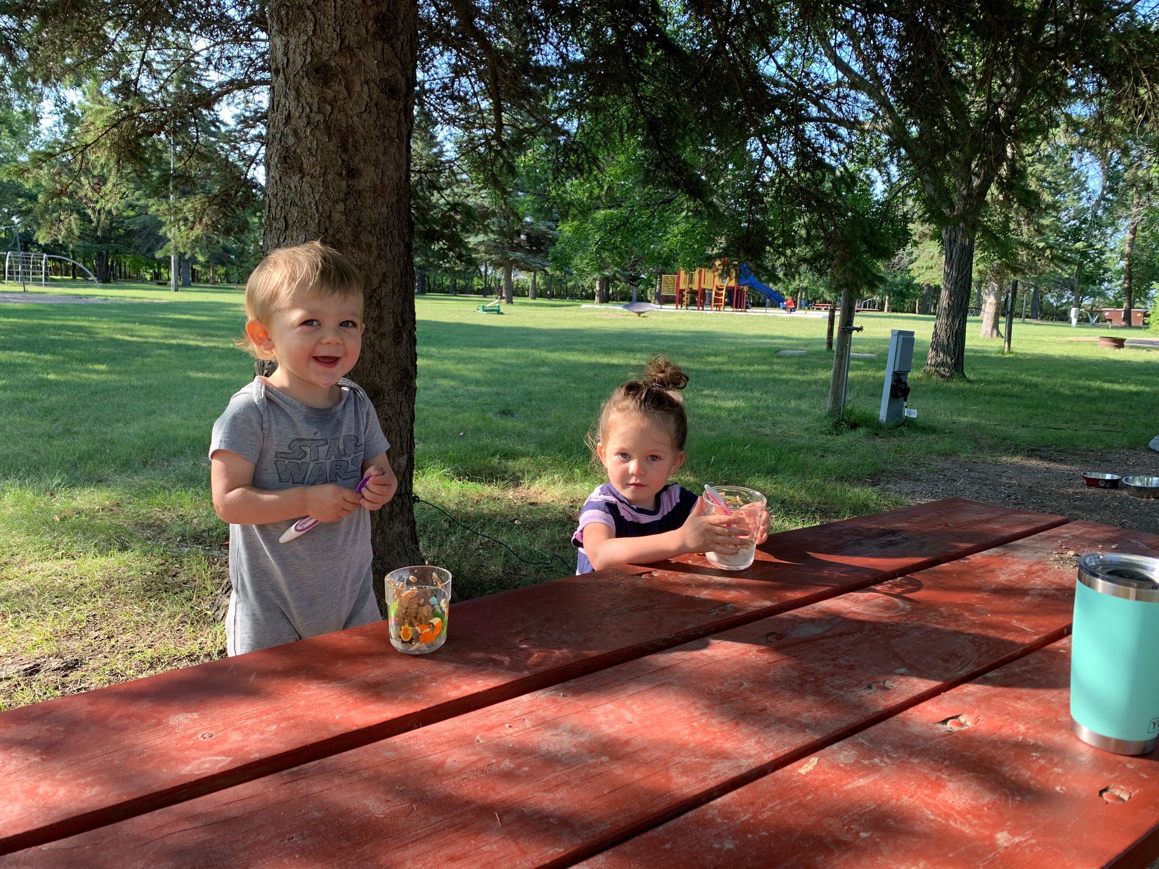 Breakfast outside at the picnic table (playground in background). Lots of green grass in between spots.