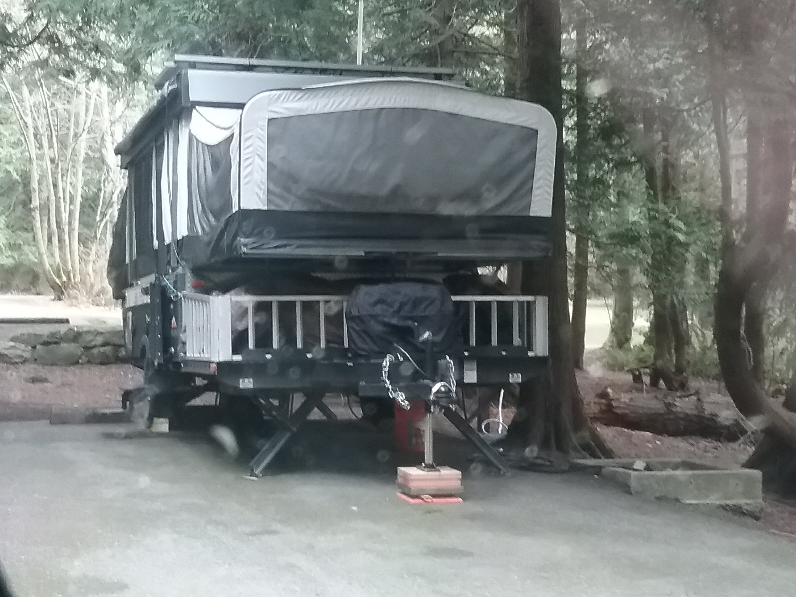 A neighboring site with a rugged off-road pop-up travel trailer