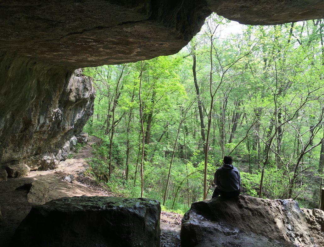 hiker sitting on a boulder in meremac state park cave