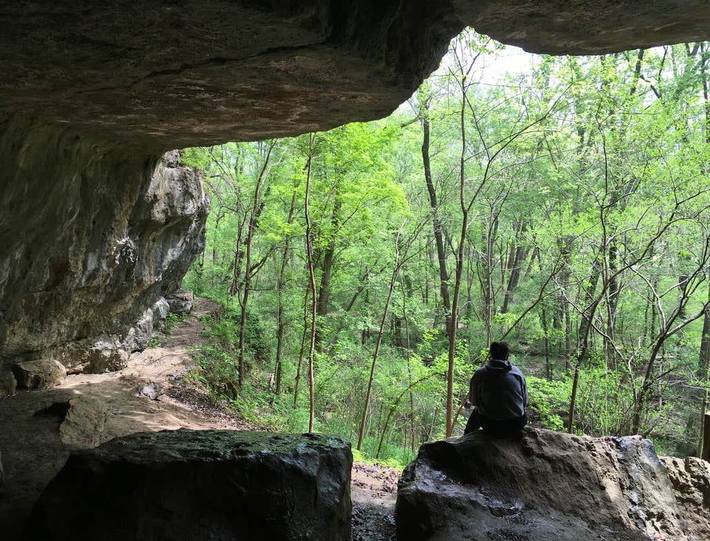 hiker sitting on a boulder in meremac state park cave