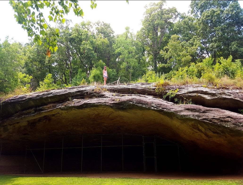 female hiker stands atop graham cave