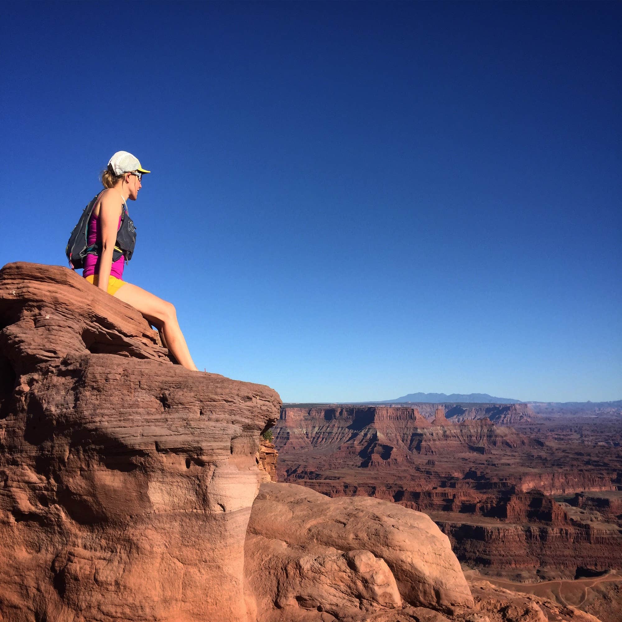 woman looking over cliff dead horse point state park, utah