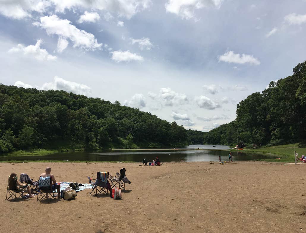 campers lounging beside the cuivre river