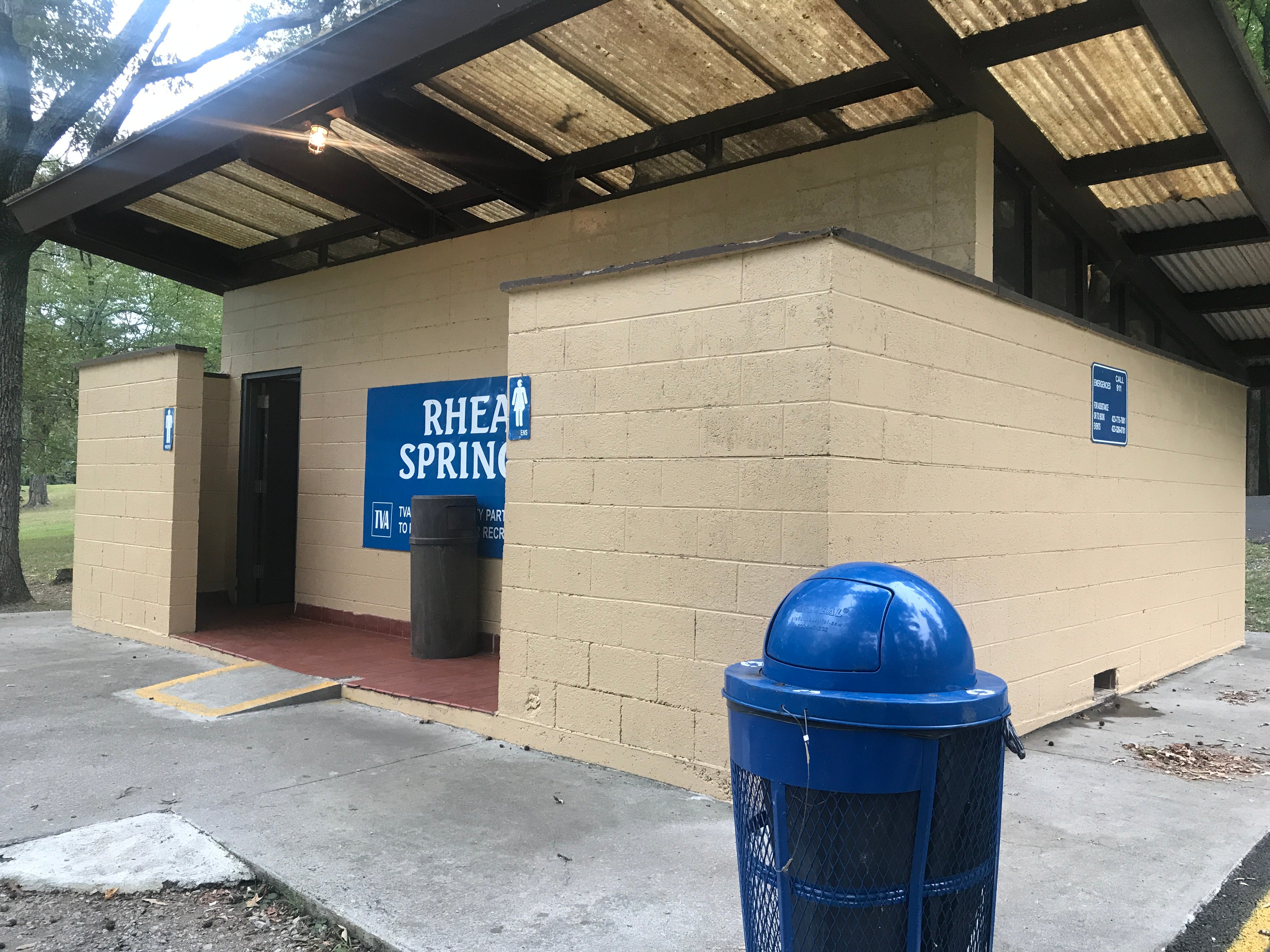 Blue recycling and black trash can be found near the entrance