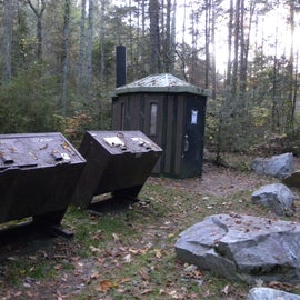 Dumpsters are close to the pit toilet.