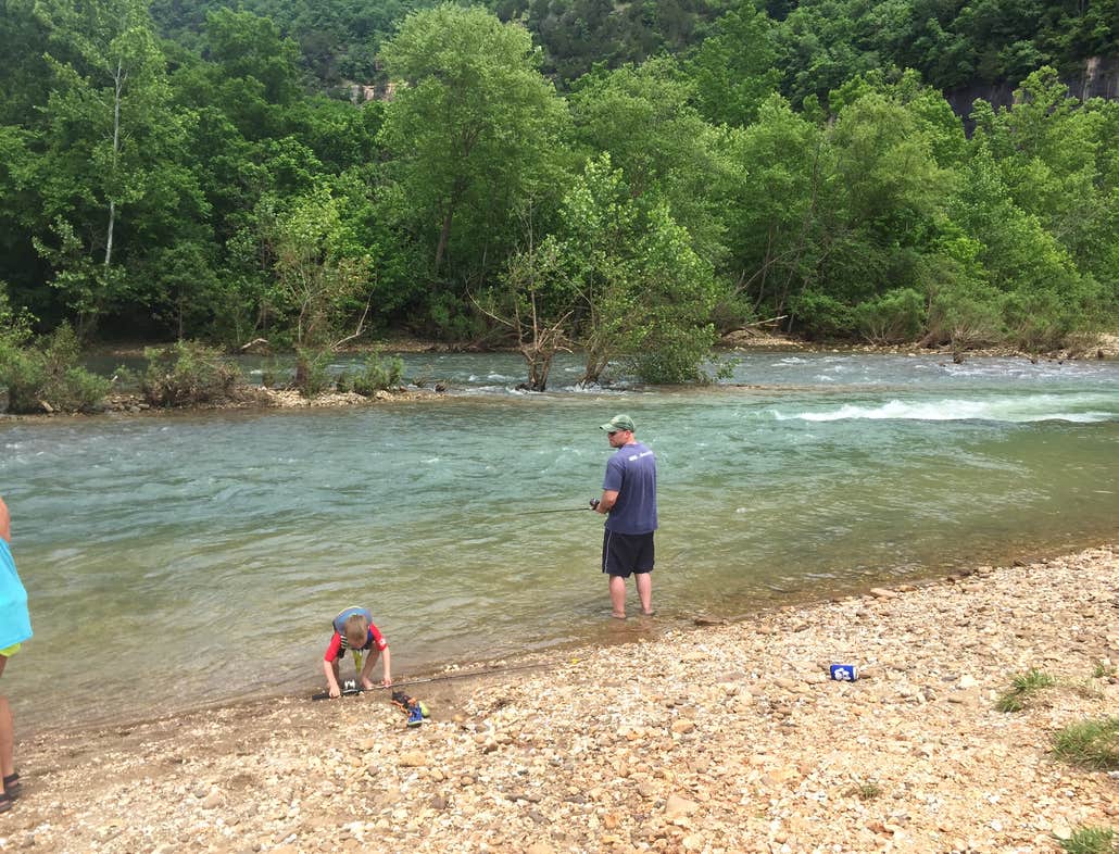 A family fishes on the shore of a river near Mill Creek Campground