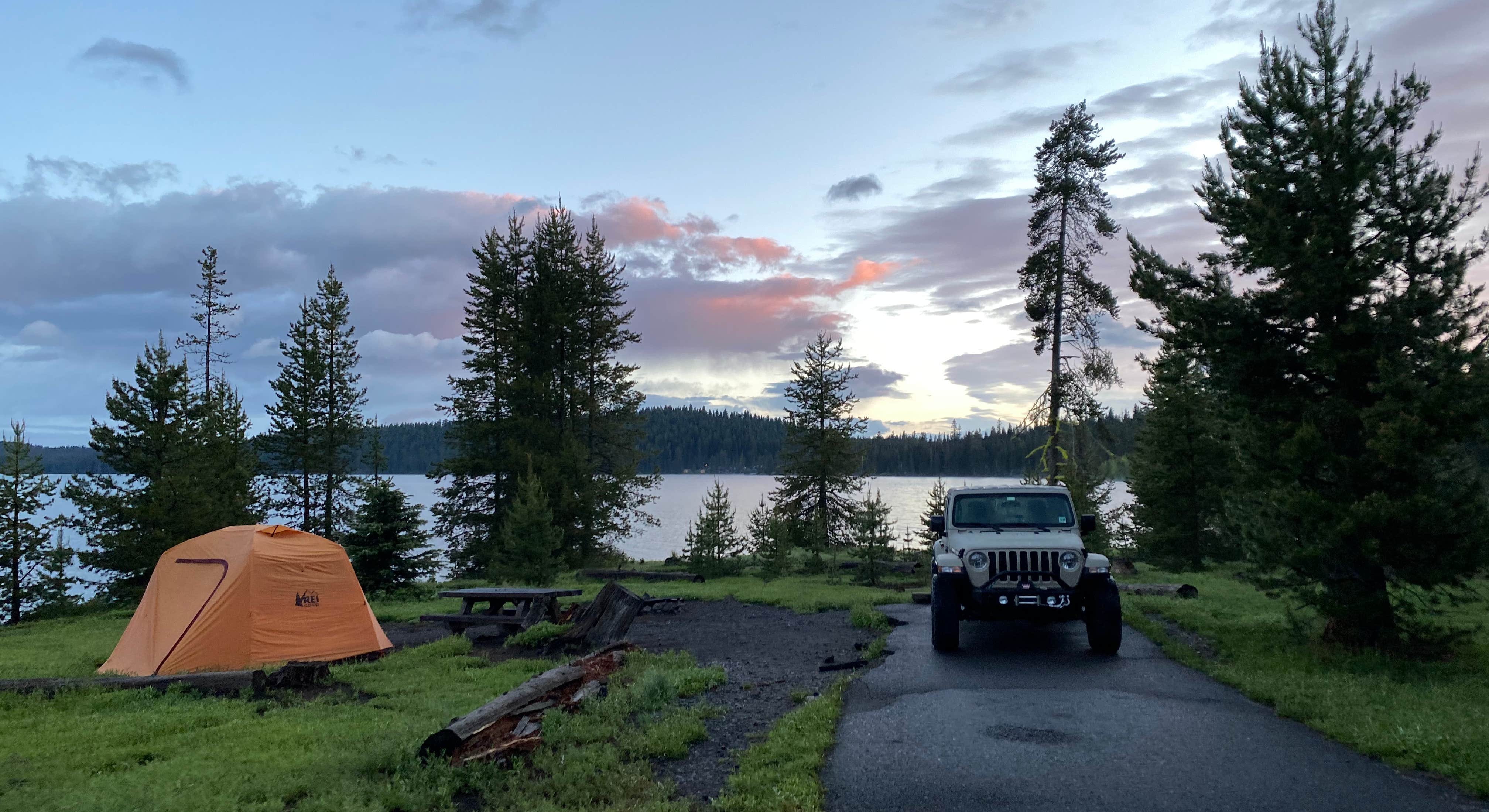 Camper at Diamond Lake with tent and view of lake in the distance, Crater Lake National Park