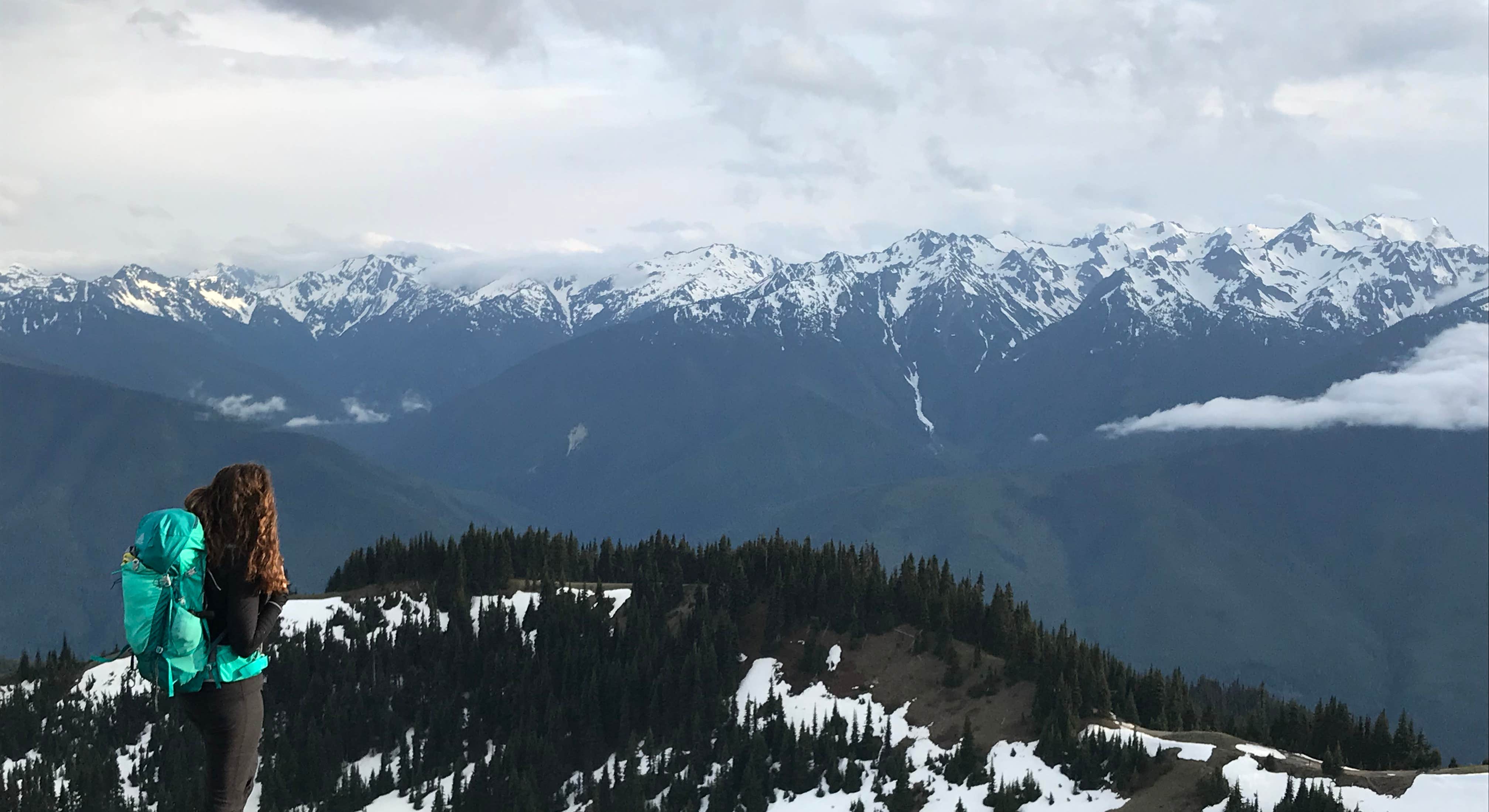 Snowy Mountain Tops with Woman Hiking Near Heart O' the Hills Campground in Olympic National Park