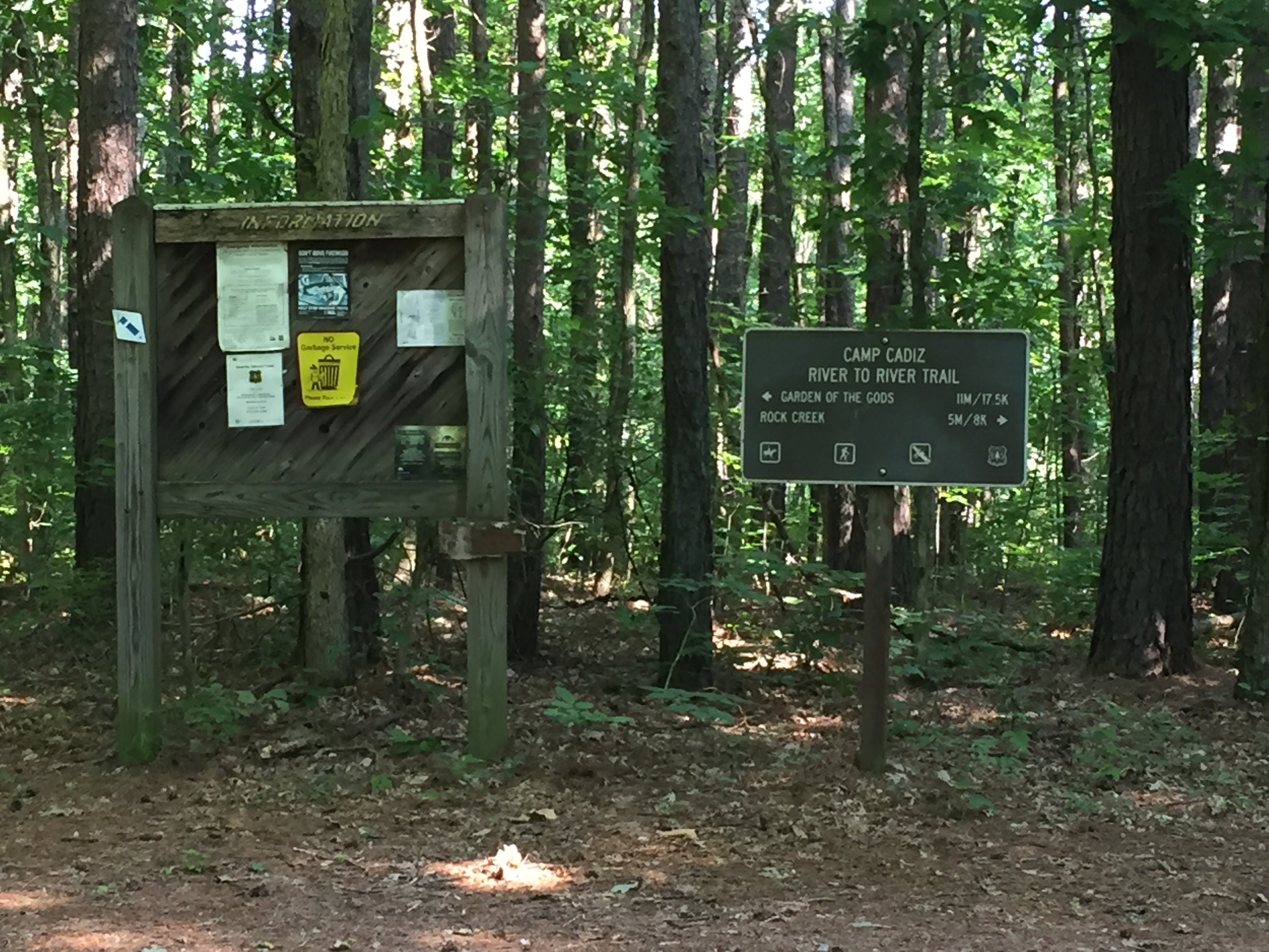 The trailhead is near sites 6 and 7 , road into the woods. 