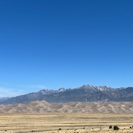 View of sand dunes and mountains beyond from the area near the RV park bathrooms