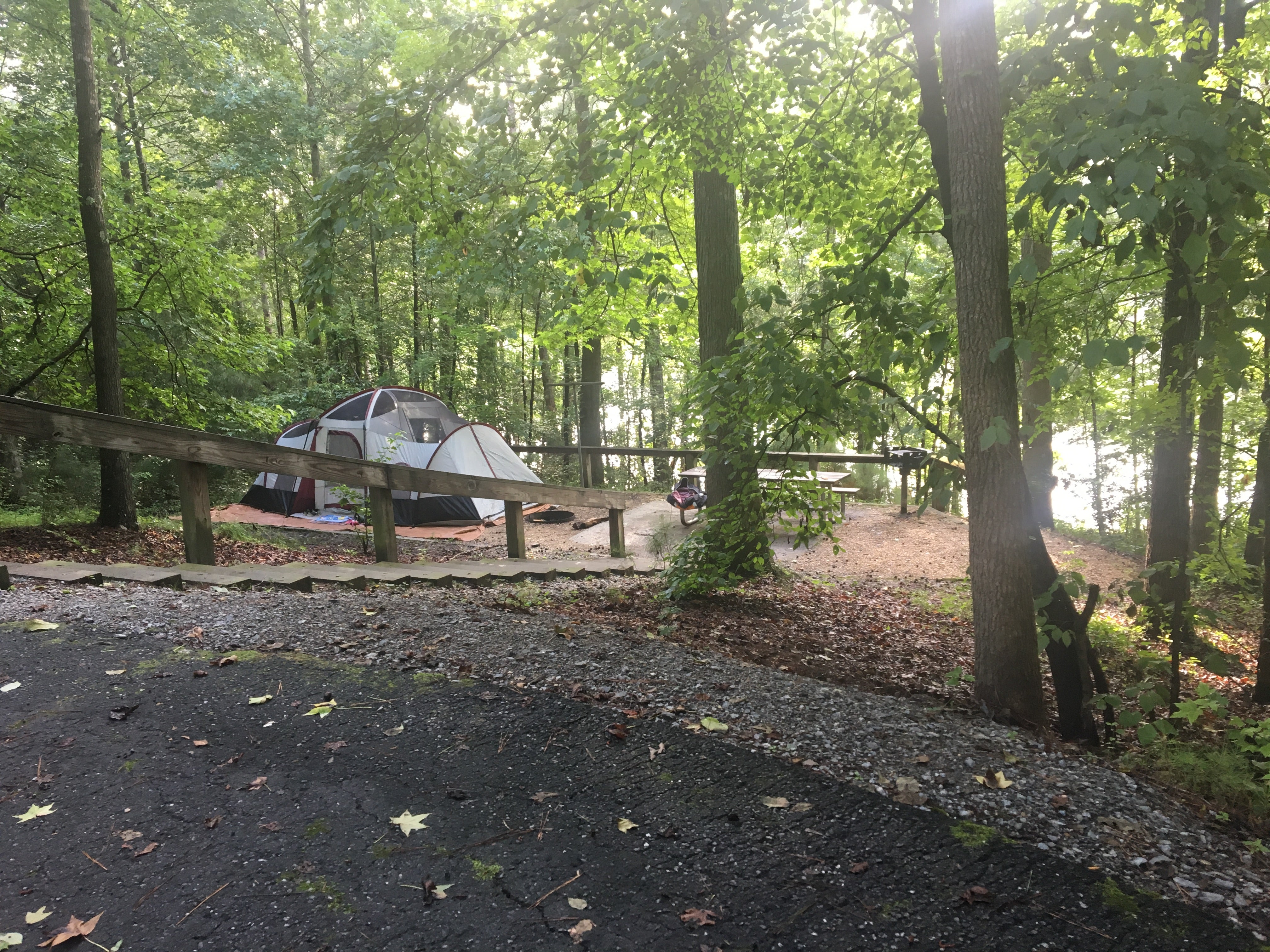 The photo was taken on the pull-through driveway of the site, looking down the staircase on the gravel pad, picnic table, and lake. The hook-ups for water and electric were on the pull-through driveway part - perfect for an RV, but up the flight of stairs for us tent folks. 
