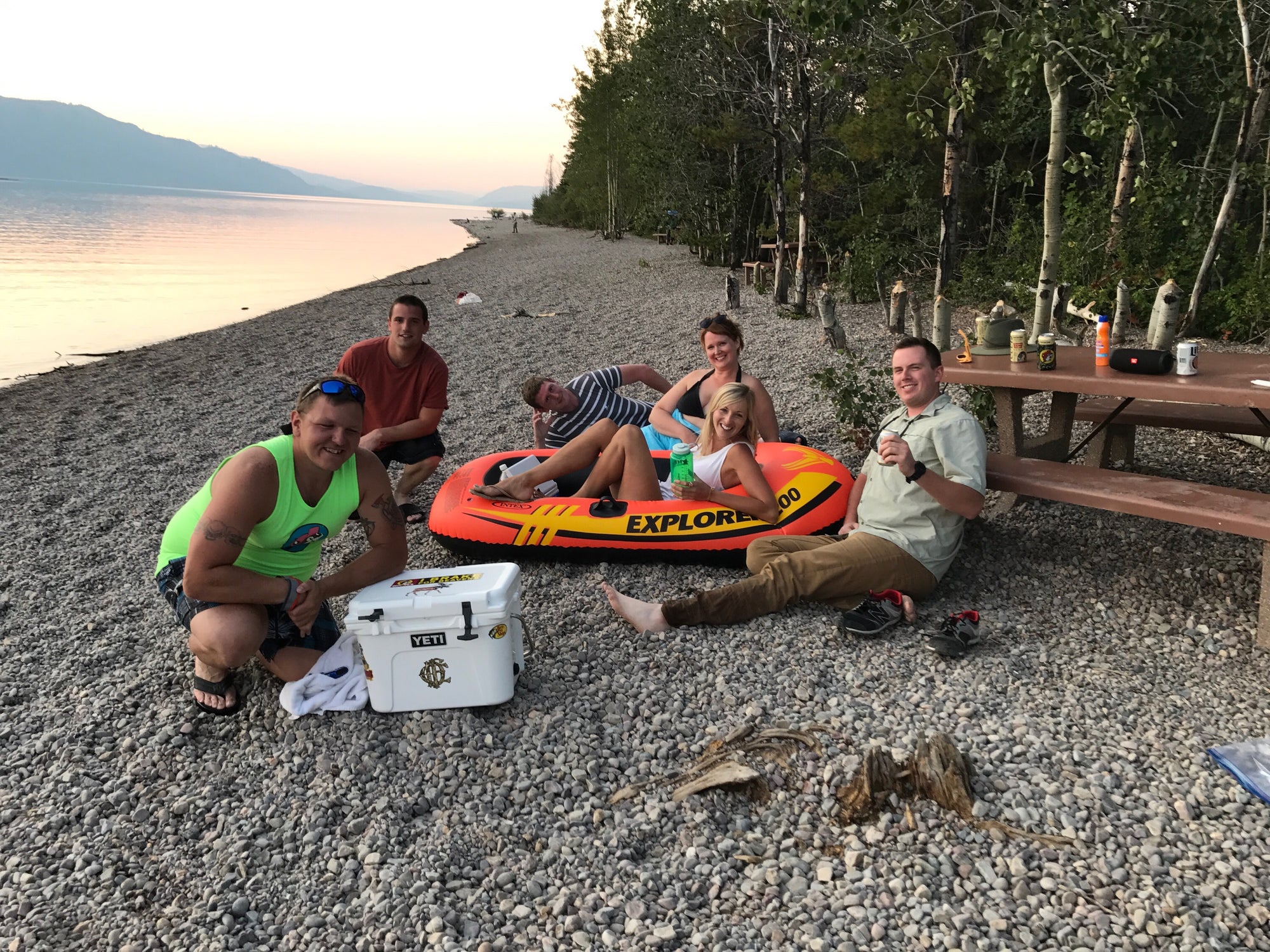 group of campers relax on the banks of jenny lake in wyoming