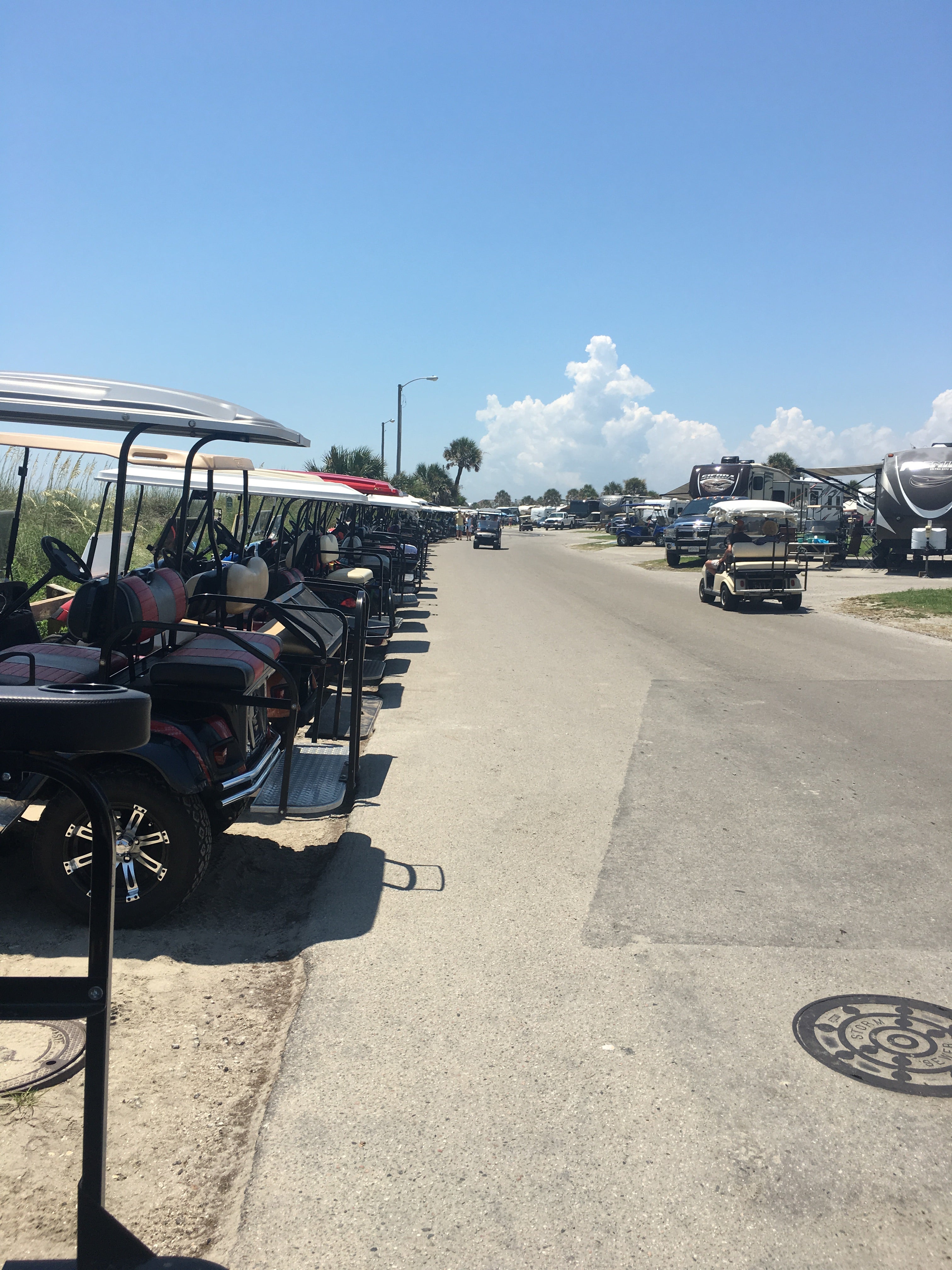 Golf cart parking by the beach. It goes all the way down the road. 